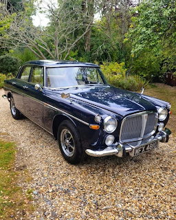 Dark blue classic1969 Rover P5B V8 Saloon parked on gravel driveway with trees in background