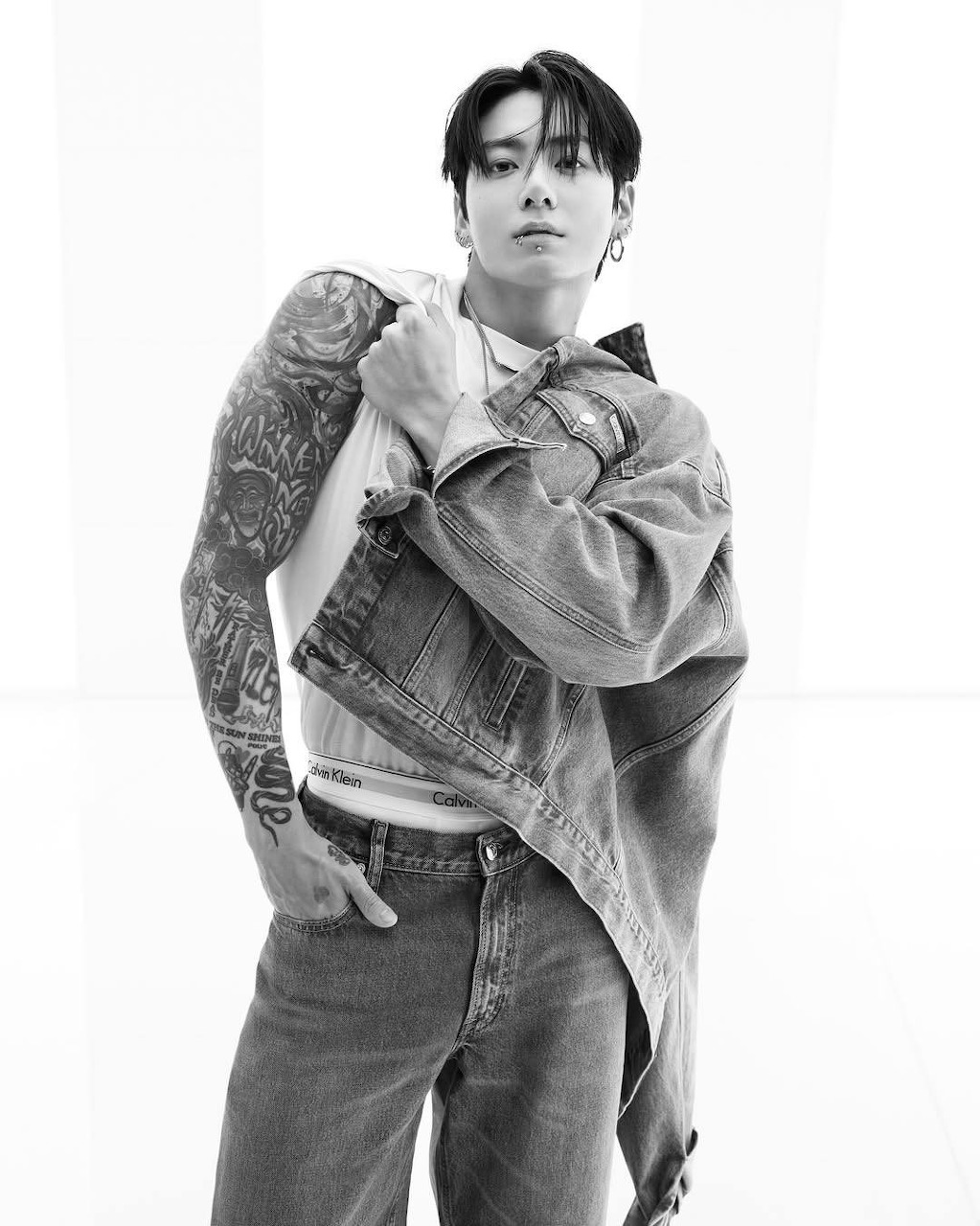 Young Asian man with sleeve tattoos in denim jacket, black and white photo