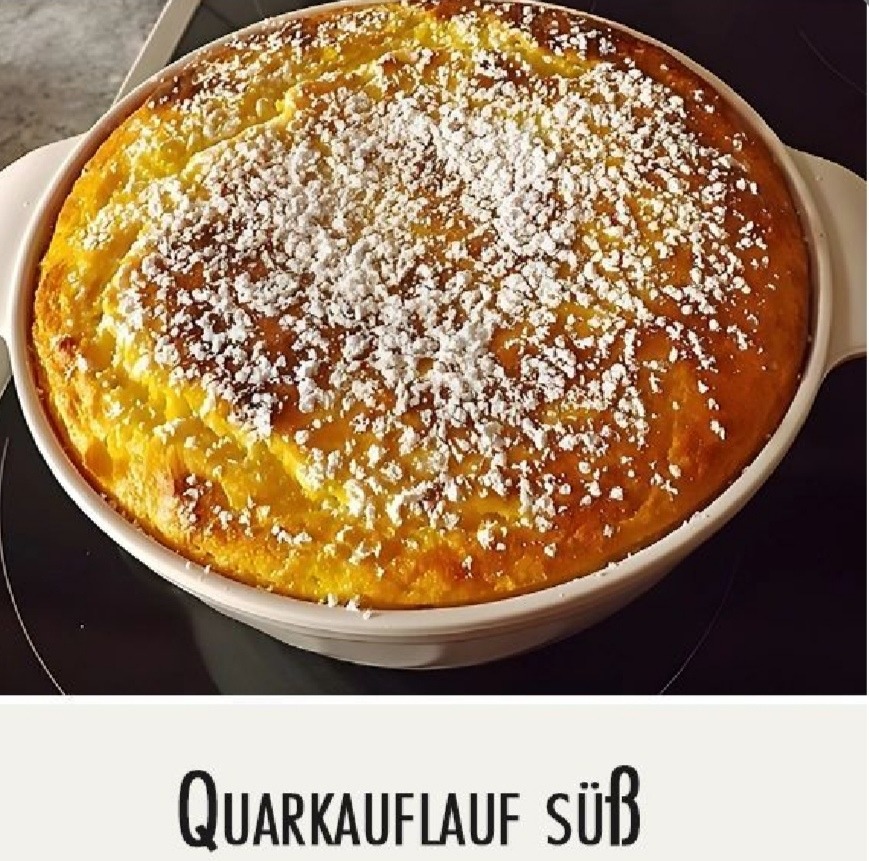 Golden baked quark soufflé topped with powdered sugar in a round white baking dish