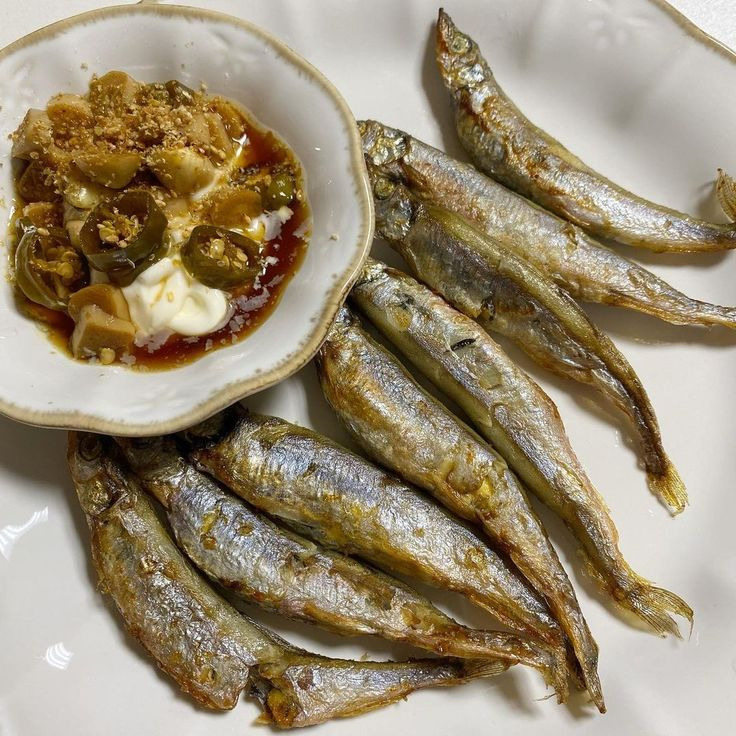 Fried sardines on white plate with spicy dipping sauce