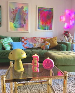 Colorful eclectic living room with green velvet sofa, mushroom lamp, neon signs, and vibrant wall art