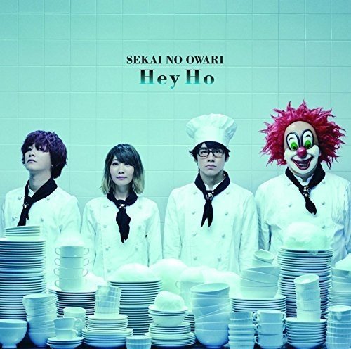 Four people in white chef uniforms behind stacks of plates, including a clown, on an album cover