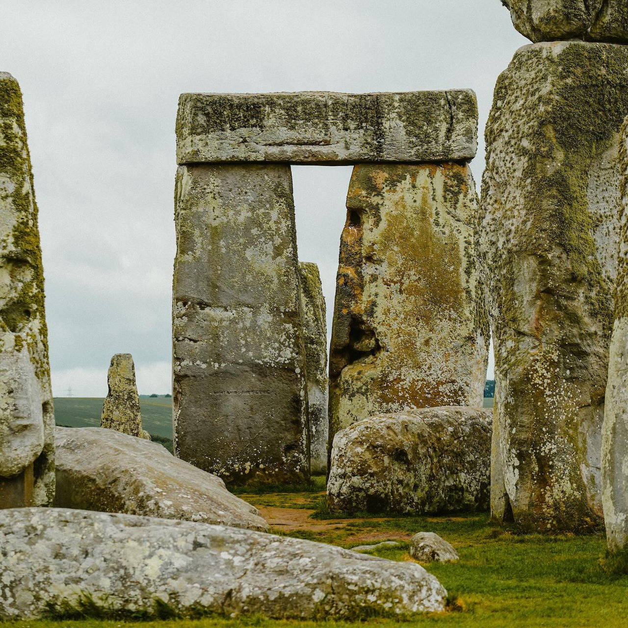 Stonehenge standing stones on grassy ground under a cloudy sky