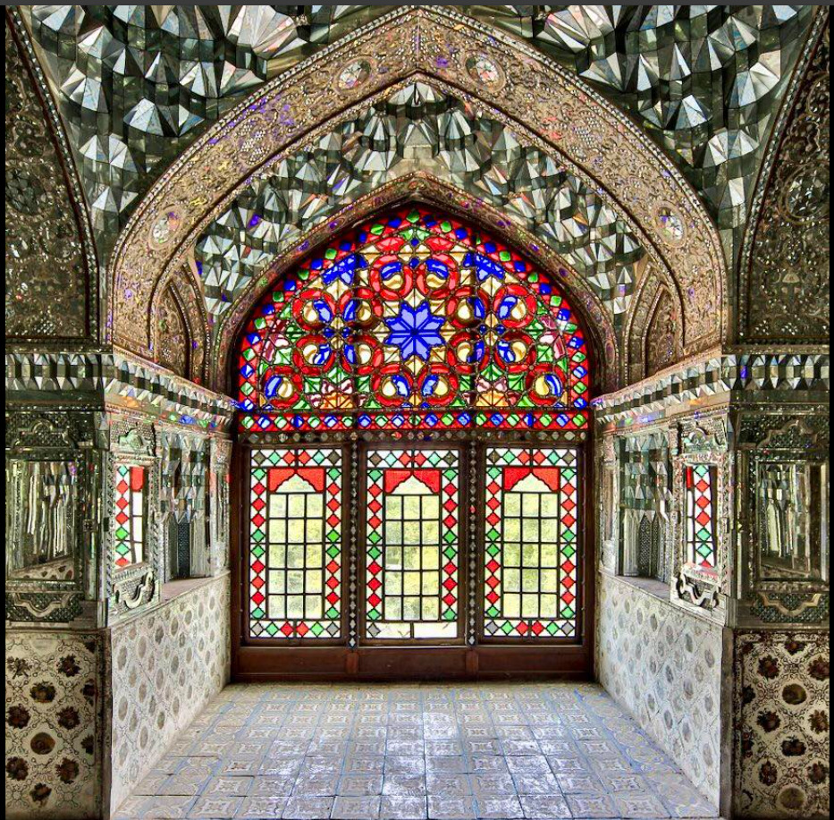 Colorful stained glass window in ornate stone archway with detailed carved patterns