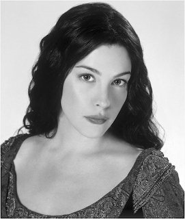 Black and white portrait photo of Liv Tyler with long dark wavy hair