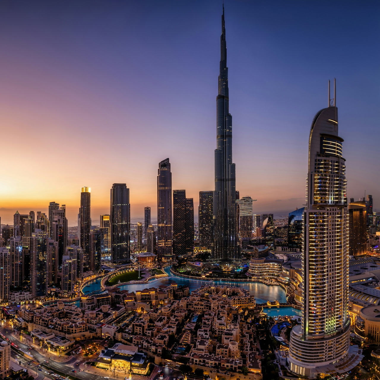 Dubai skyline at sunset with Burj Khalifa and illuminated skyscrapers