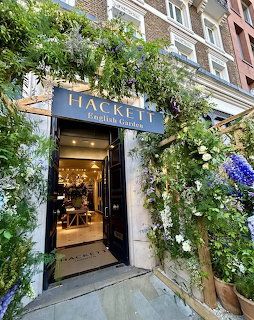 London shop entrance decorated with cascading white and purple flowers and greenery