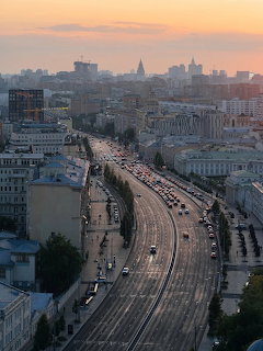 Aerial view of Moscow at sunset showing curved railway tracks and city skyline