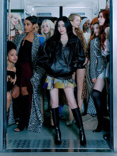 Group of fashionable young women posing in a subway train doorway wearing stylish outfits