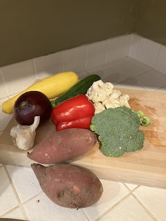 Fresh vegetables arranged on a wooden cutting board on a kitchen counter