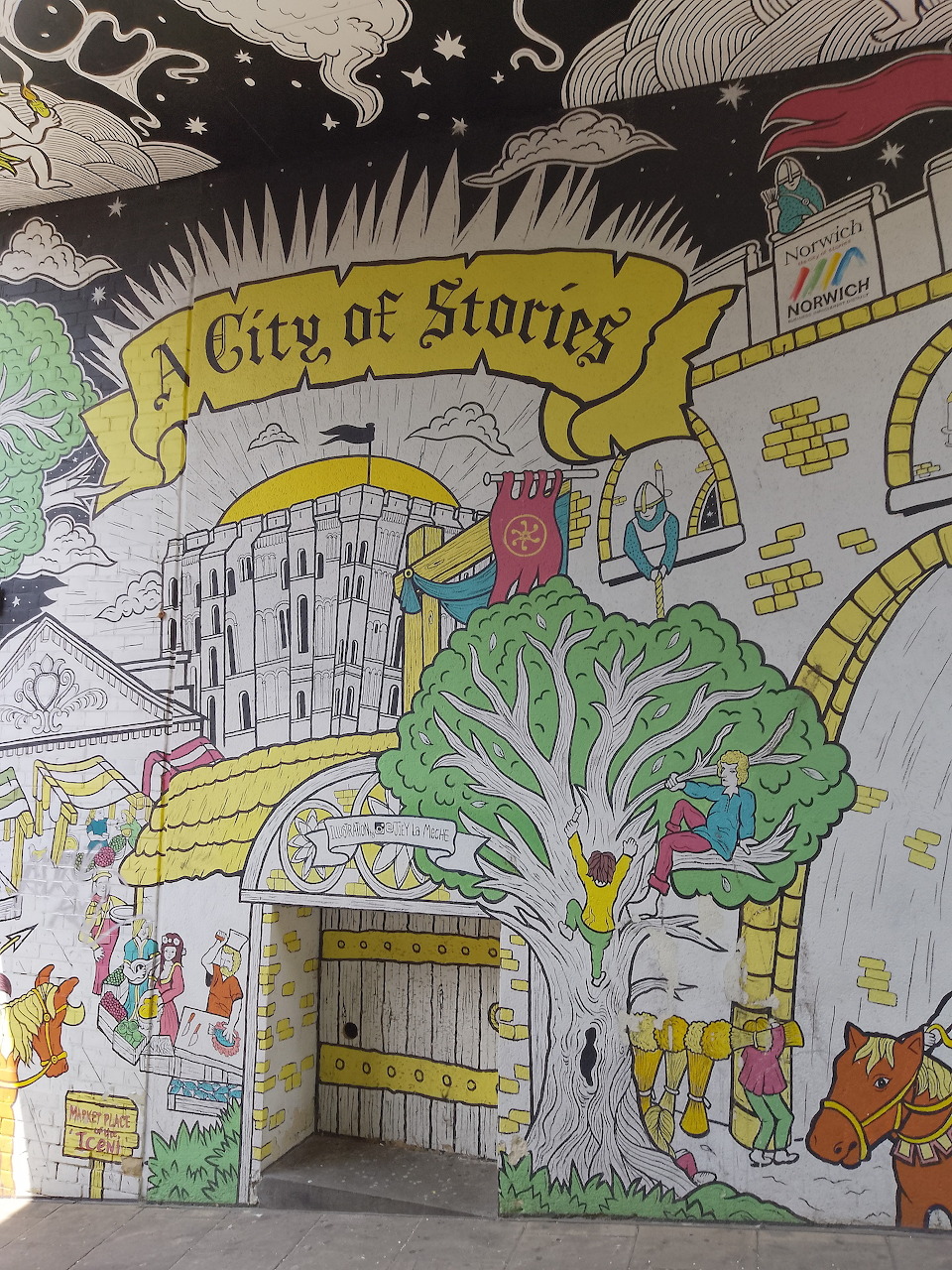 Illustrated mural showing Norwich city landmarks with castle, cathedral, tree and yellow banner reading City of Stories