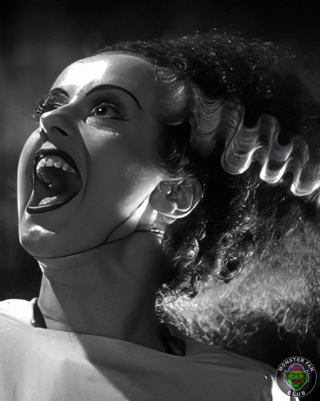 Black and white close-up of the Bride of Frankenstein with wild hair and screaming expression