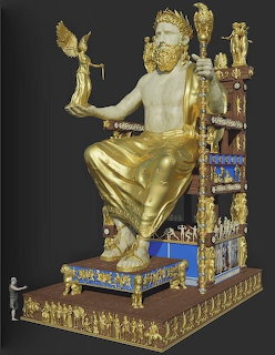 Golden statue of Zeus seated on decorated throne against dark background
