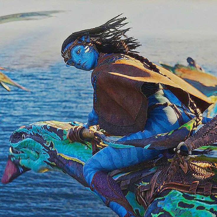 Blue Na'vi warrior Neteyam with long black hair riding over ocean water