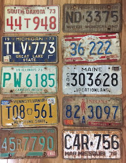 Collage of vintage U.S. license plates on weathered wooden boards