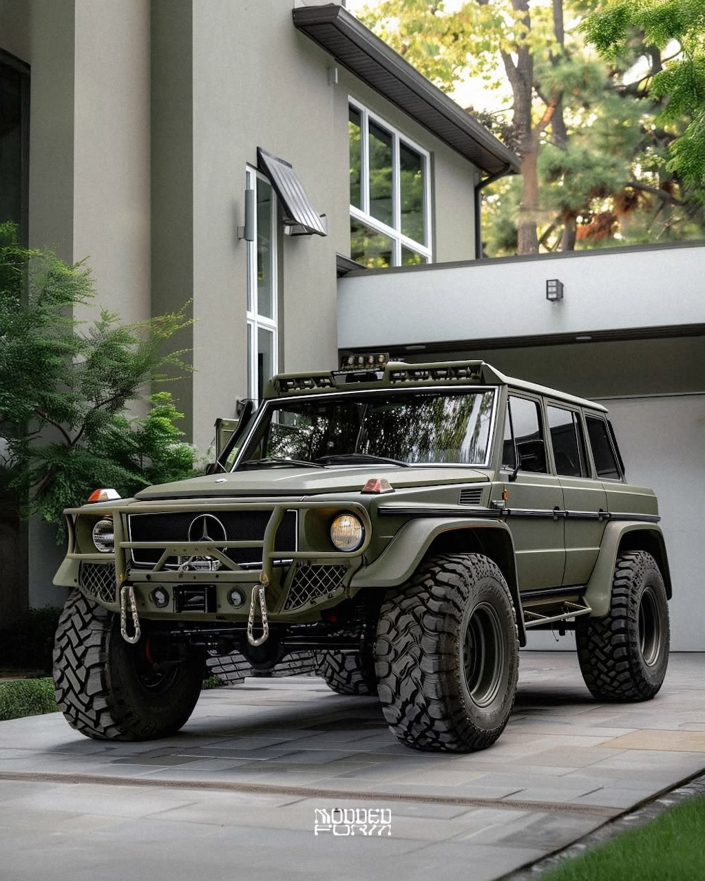Modified olive green Mercedes G-Wagon 4x4 with large off-road tires parked in a driveway