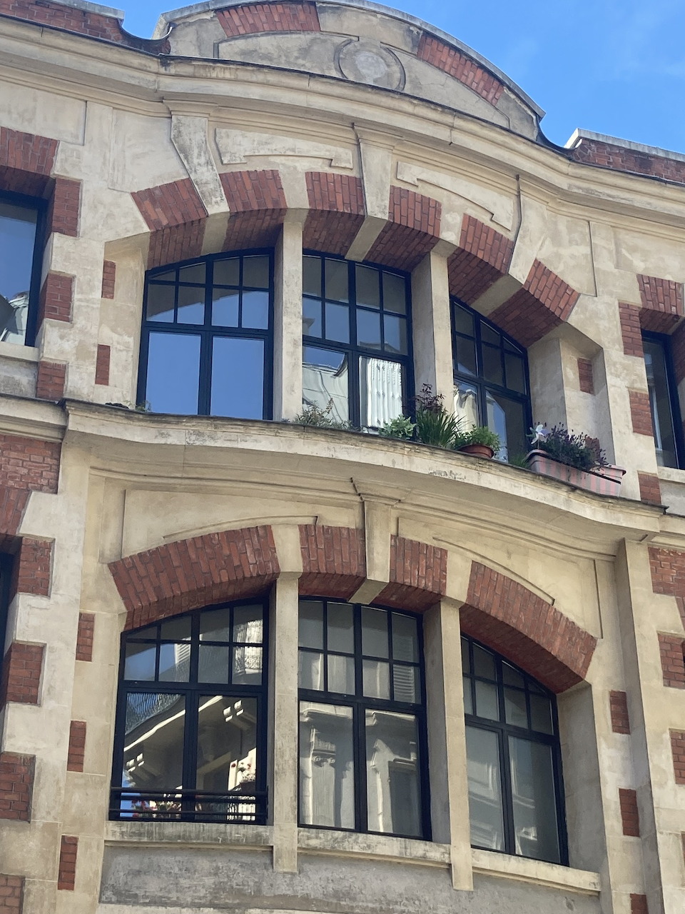Parisian Haussmann building facade with wrought iron balconies and tall windows