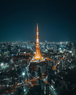 Tokyo Tower lit up at night above a sprawling city skyline