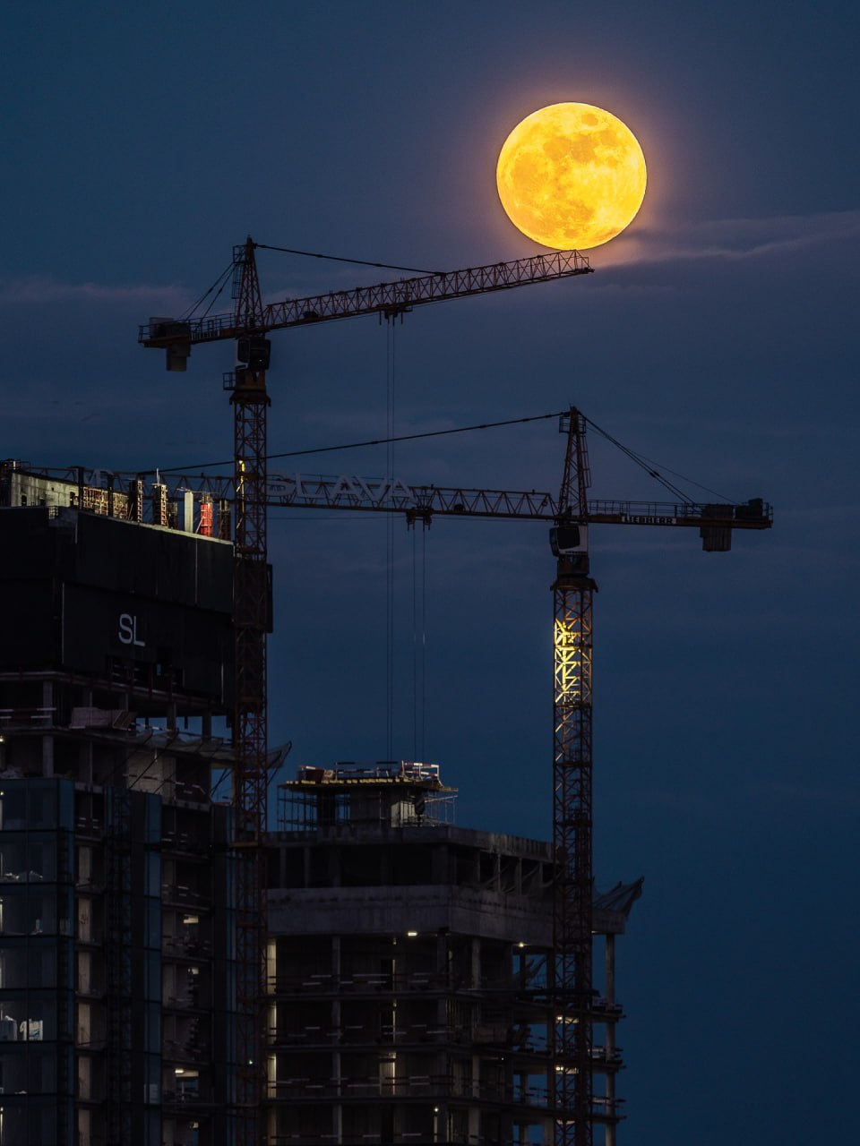 Full Moon Over Construction Cranes