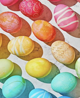 Colorful dyed Easter eggs in rainbow arrangement with various decorative patterns including stripes and speckles
