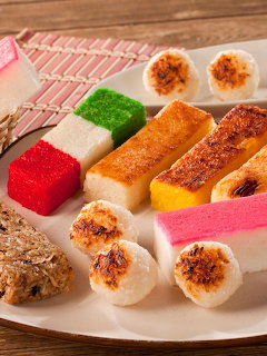Assortment of colorful traditional Asian rice cakes and sweets arranged on a white plate