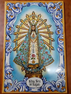Ceramic tile depicting the Virgin of Luján with ornate blue border and golden rays