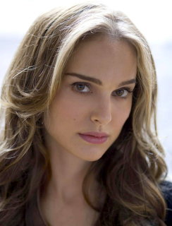 Close-up portrait of Natalie Portman with wavy brown hair and a neutral expression