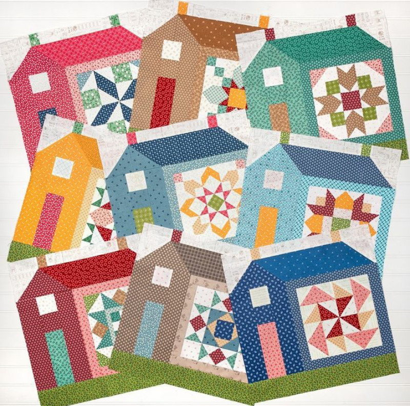 Fabric quilt with colorful house blocks showing geometric patterns and patchwork designs