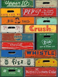 Stack of colorful vintage wooden soda crates with brand logos including Pepsi, Coca-Cola, 7UP, and Orange Crush