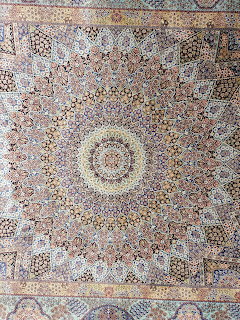 Ornate Persian carpet with intricate mandala pattern and geometric floral designs in earth tones