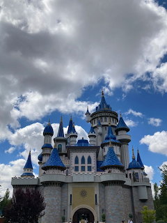 White castle with multiple blue-topped turrets under cloudy sky