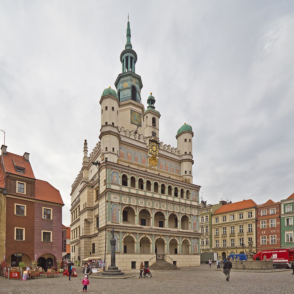 Renaissance town hall in a European city square with an ornate tower and surrounding historic buildings