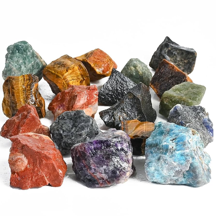 Assorted rough gemstones and mineral rocks on a white background