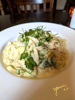 Creamy pasta dish garnished with fresh herbs on a white plate