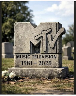 Stone tombstone carved in the shape of the MTV logo reading Music Television 1981-2025 in a grassy cemetery