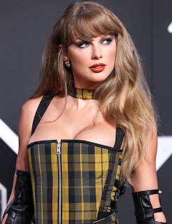 Taylor Swift wearing a yellow plaid corset dress at an event
