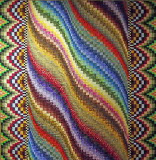 Colorful patchwork quilt made of square fabric patches with mixed prints