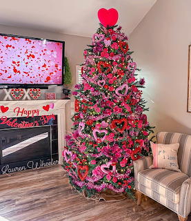 Christmas tree decorated with red hearts, pink roses, and Valentine's Day ornaments in living room
