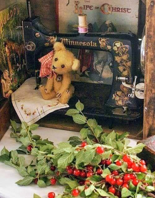 Vintage Minnesota sewing machine with teddy bear and red berry garland on white table