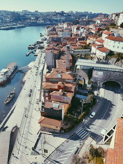 Aerial view of Porto riverside with colorful buildings, terracotta rofs, road tunnel, and Douro River