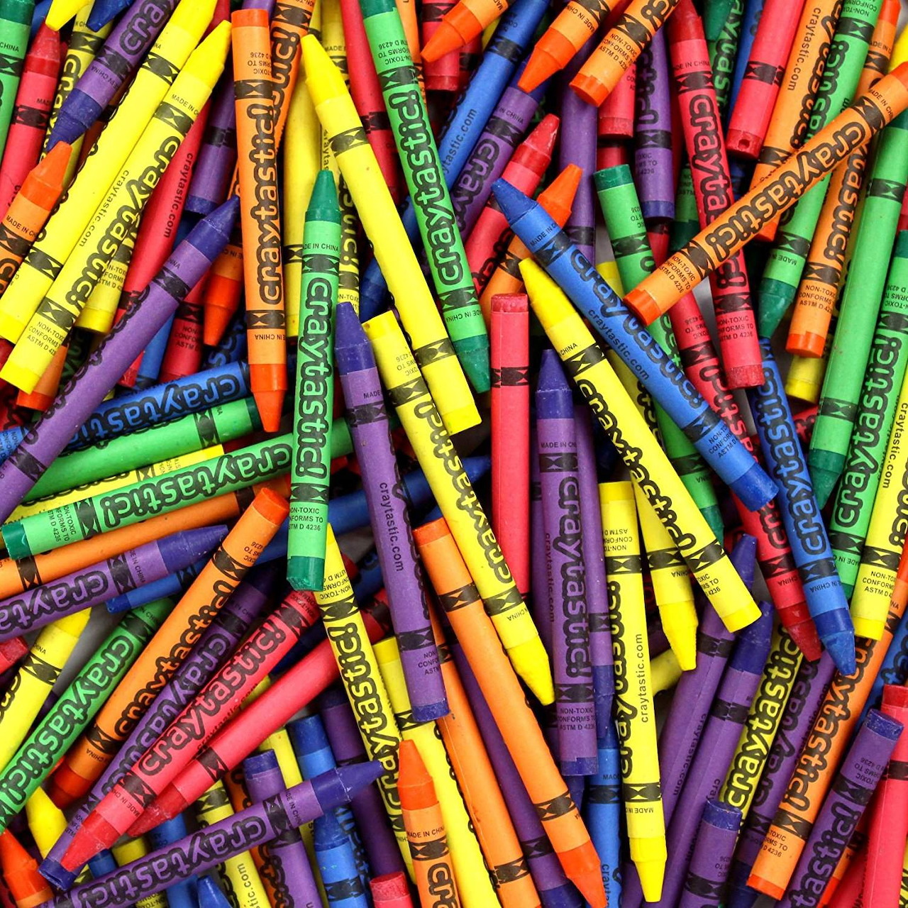 Colorful crayons scattered in a random pile showing various bright colors and brand labels