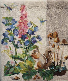 Woodland-themed patchwork quilt with earthy fabric squares in a grid layout.