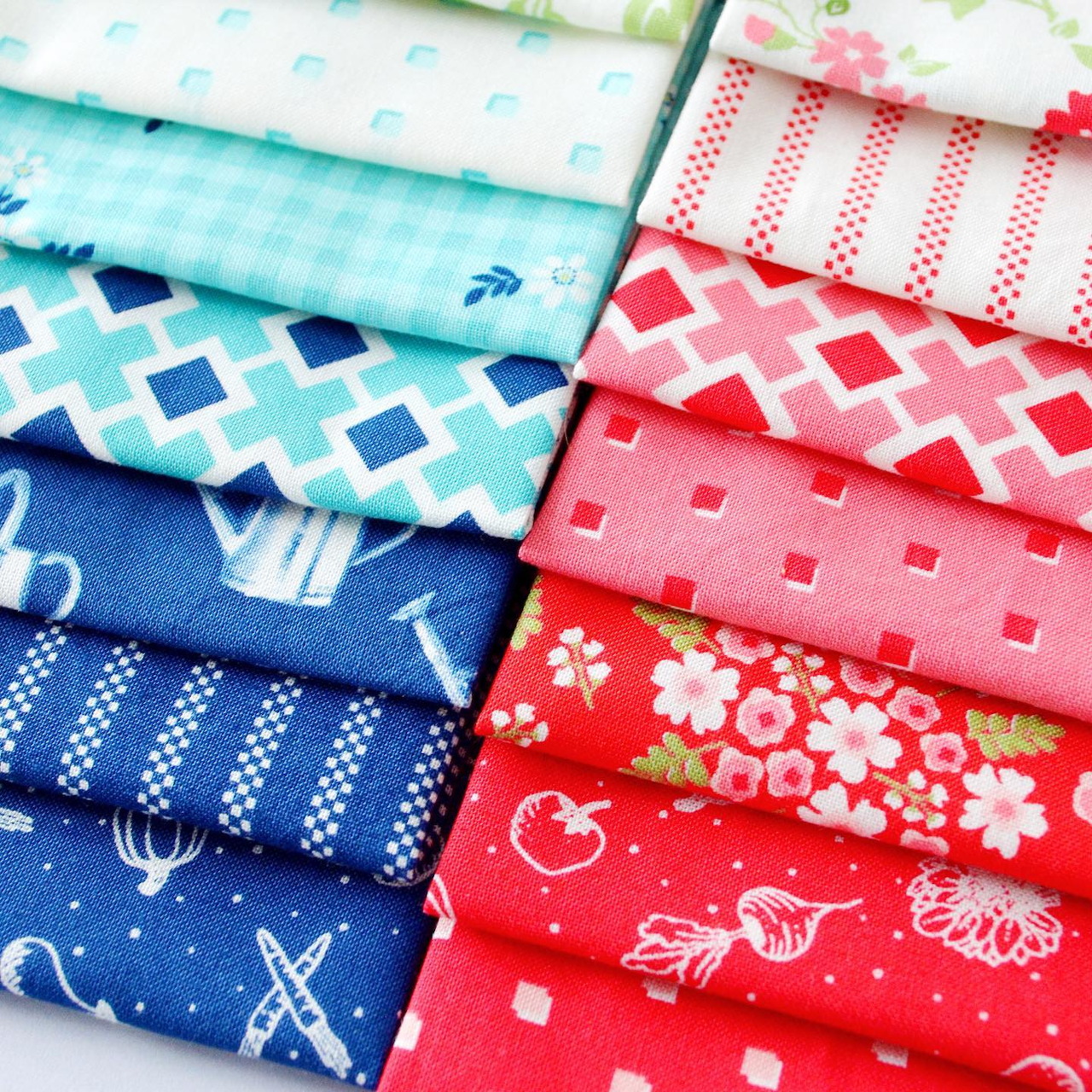 Stack of folded fabric fat quarters in blue and red patterns including gingham, florals, and polka dots