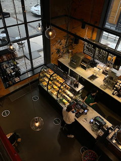 Aerial view of Starbucks coffee shop interior with wooden furniture, display counter, and customers