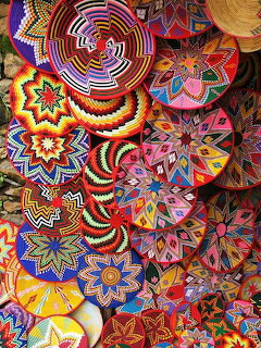 Colorful handwoven baskets with intricate geometric patterns in red, blue, yellow, and purple