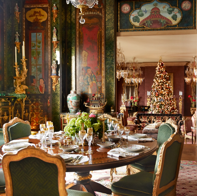 Ornate mansion dining room with Christmas tree, formal table setting, antique furniture, and elaborate holiday decorations