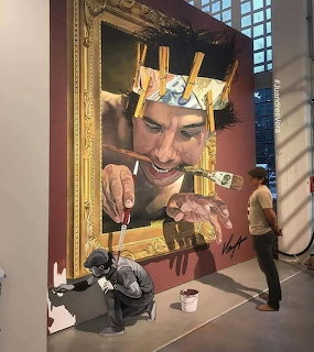 Large mural showing a man painting himself with a real person posing as if creating the artwork