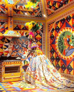 Richly decorated room with multicolored mosaic walls, patterned ceiling, ornate furniture and flowing fabrics