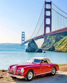Vintage red Alfa Romeo convertible at Golden Gate Bridge waterfront