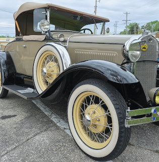 Close-up of a beige and black 1930 Ford vintage car with whitewall tires